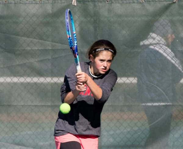 Merri Kelly playing tennis in pink skirt