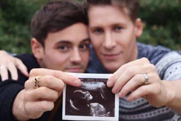 Tom Daley and Lance Black showing the picture of heir kid