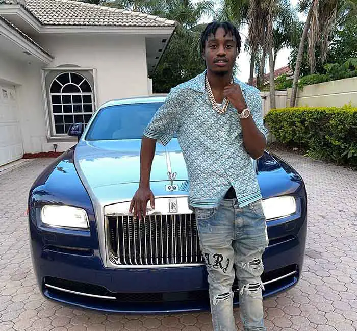 Image of rapper, Lil Tjay and his car