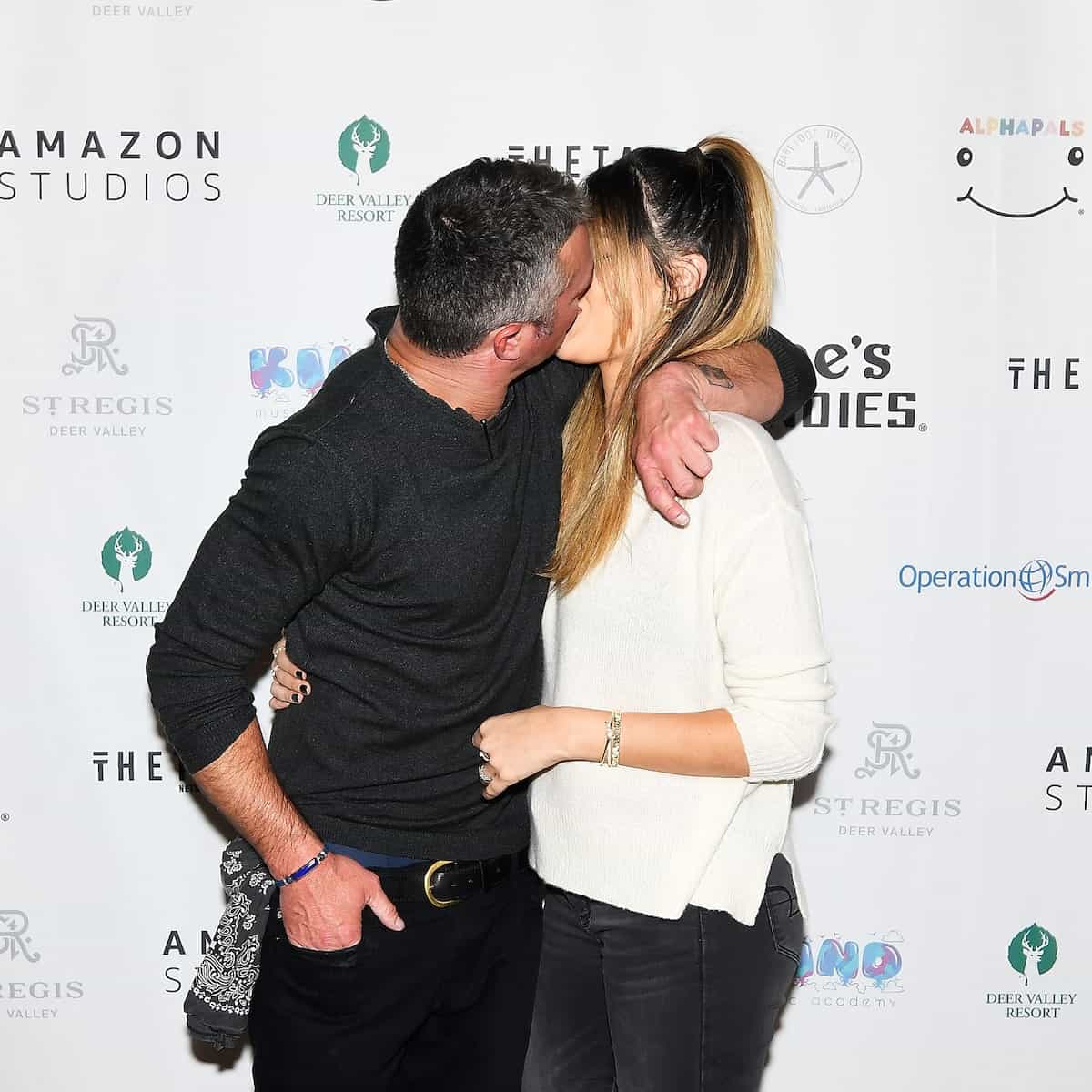 Image of Taylor Kinney kissing his girlfriend, Ashley Cruger