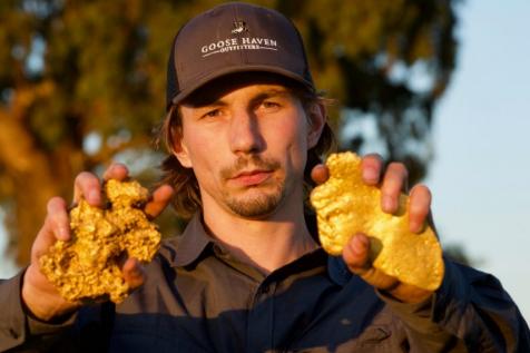 Image of Parker Schnabel with gold nuggets on his hands