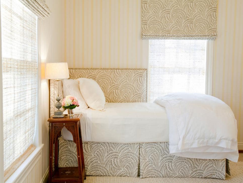 Image of a small room with a a twin bed with a corner-style headboard