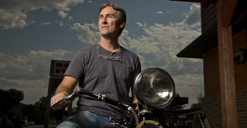 Image of American Picker Star Mike Wolfer in a black shirt riding a motor